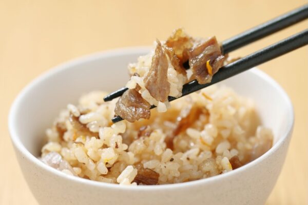 きっぽ常連支持率No.1のコウネ飯。こうねの旨みが染み込んだ炊き込みご飯を箸で持ち上げている様子