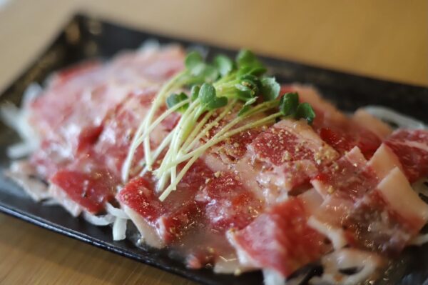 きっぽのコウネカルパッチョ。新鮮なこうねを薄くスライスし、かいわれ大根を添えた一皿